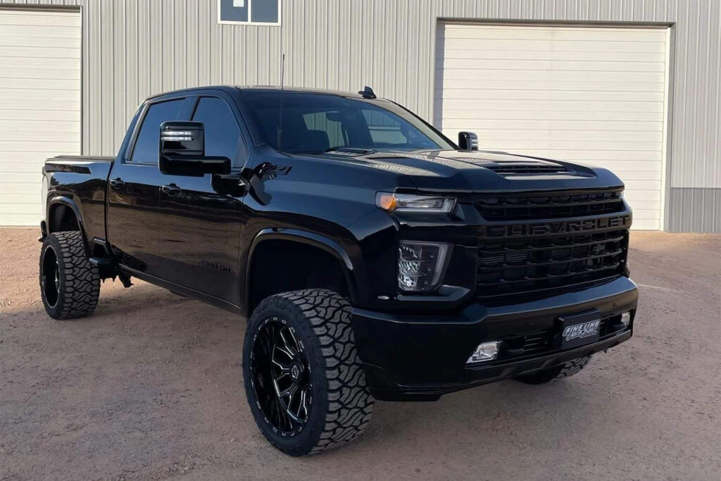 Black pickup truck parked in front of garage.