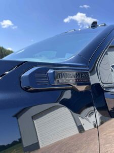 Close-up of a black car's side mirror with a warning label.