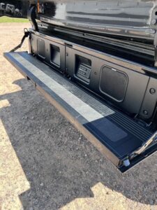 Open tailgate of a pickup truck with a textured step surface.