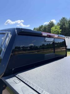 Black truck cap with tinted windows on a pickup truck.