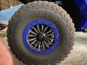 Close-up of a rugged off-road tire with a blue and black wheel rim.