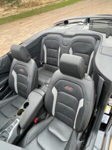 Luxury convertible car interior with leather seats and headrests.