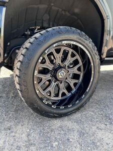 Black custom off-road truck tire with stylish alloy rim.