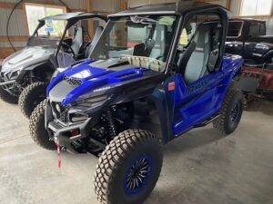 Blue off-road utility vehicle parked indoors.