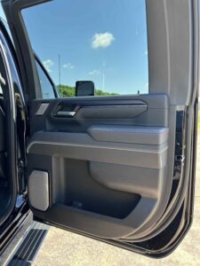 Open car door showing detailed interior panel with storage compartments.