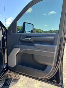 Interior view of a vehicle's driver side door with window and mirror controls.