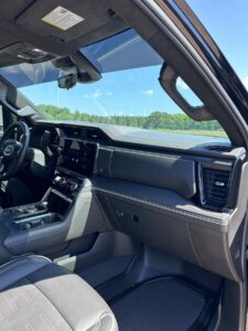 Interior view of a modern car with a touchscreen dashboard and scenic outdoor background.