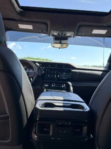 Interior view of a modern car from the back seat showing the dashboard and front seats.