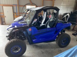Blue off-road utility vehicle parked inside a garage.