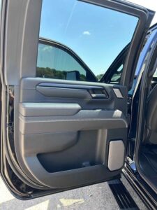 Open car door showing detailed interior panel with storage compartments.
