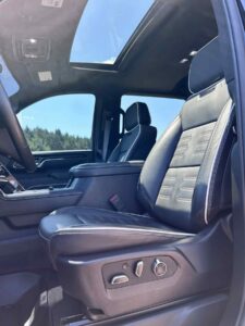 Luxurious black leather car seats with adjustable controls and a sunroof overhead.