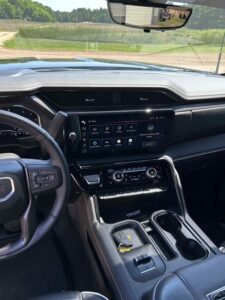 Modern car dashboard with digital display and steering wheel controls.