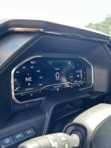 Digital dashboard showing speed and navigation direction in a vehicle.
