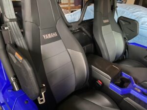 Two black Yamaha-branded car seats with blue ambient lighting inside a vehicle.